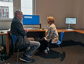 Wilfried Laudehr und Melanie Schlotzhauer sitzen vor einem Computerarbeitsplatz