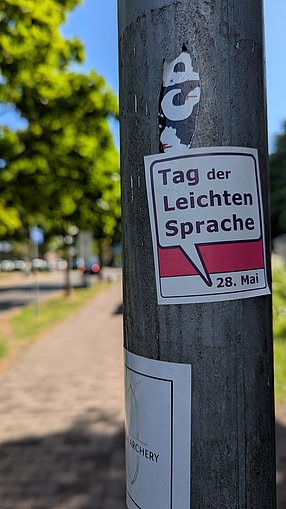 Sticker auf Laternenpfahl, auf dem steht: Tag der Leichten Sprache! 28. Mai