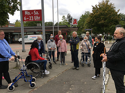 a group of people, many using mobility aids, on an urban street