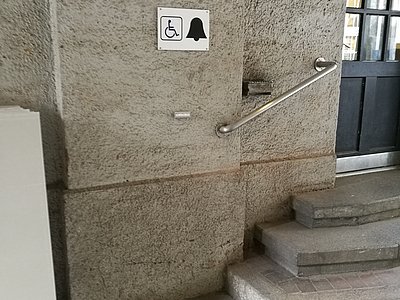 Symbolbild Klingel für Rollstuhlfahrende vor Treppe