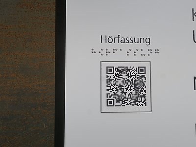 Tafel mit Braillebeschriftung und QR-Code