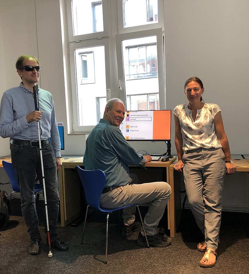 Heiko Kunert, Wilfried Laudehr und Frauke Untied stehen bzw. sitzen am PC-Arbeitsplatz und schauen in die Kamera