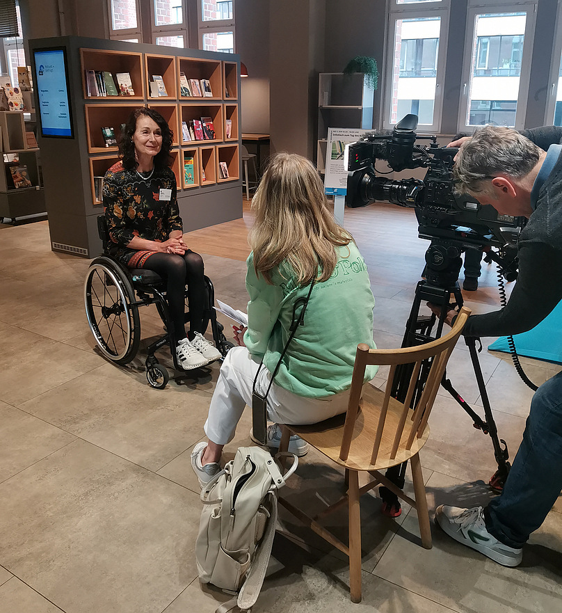 Sylvia Pille-Steppat wird vor einem Bücherregal von einem Kamerateam interviewt